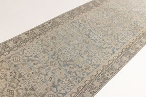 A vintage Persian Malayer runner in blue tones — this hand-knotted antique carpet showcases an all-over design.