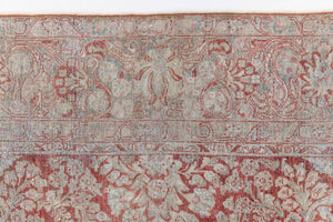 Detail of a genuine antique Persian Sarouk carpet in red and blue tones, a handmade rug with a floral medallion design.