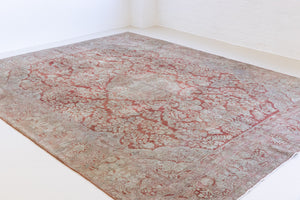 A vintage Persian Sarouk carpet in red and blue tones — this hand-knotted antique rug showcases a floral medallion design.