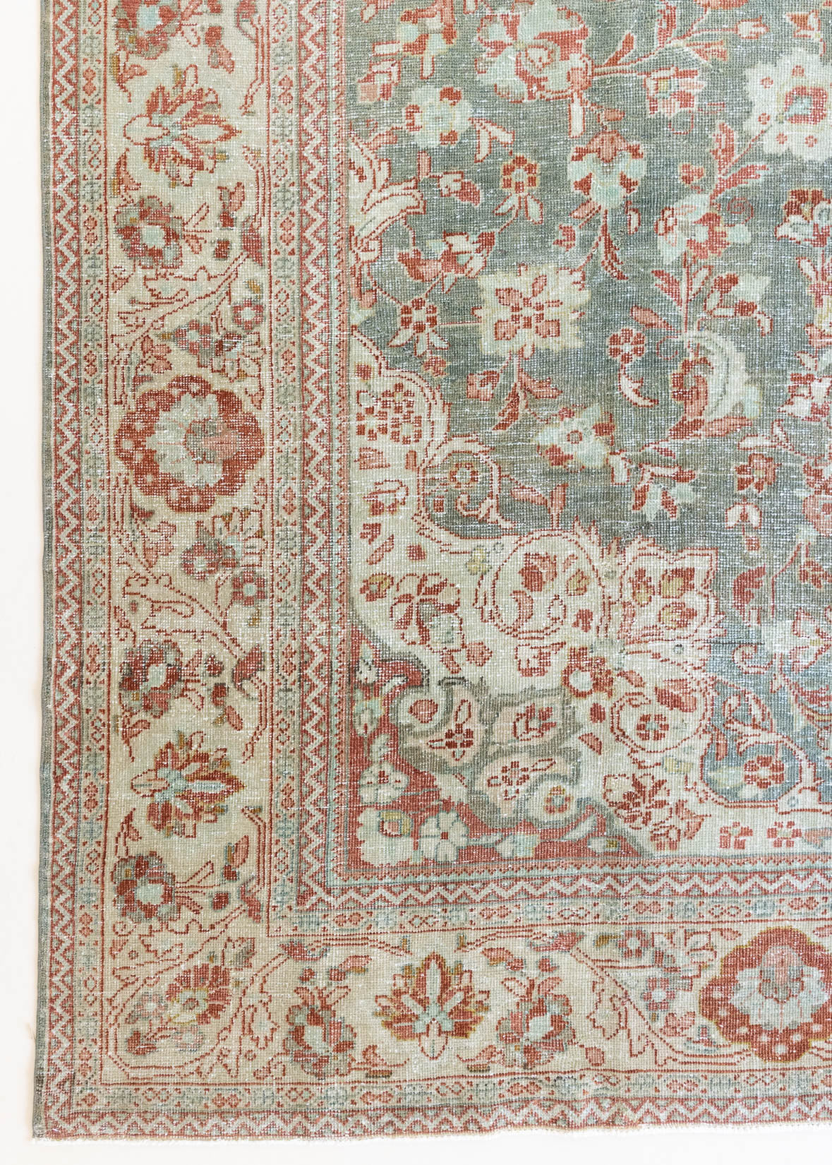 Electra is an antique Persian Tabriz rug with a lovely muted blue colour palette featuring a beautiful rustic red and ivory border alongside an intricate central medallion design within the vintage carpet. 