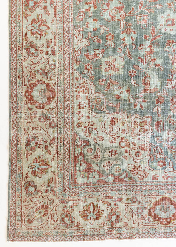 Electra is an antique Persian Tabriz rug with a lovely muted blue colour palette featuring a beautiful rustic red and ivory border alongside an intricate central medallion design within the vintage carpet. 