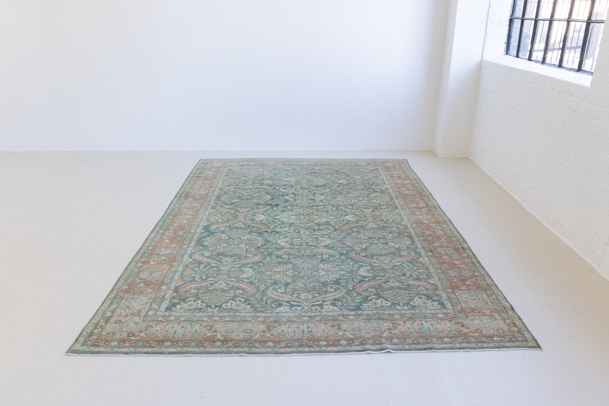 A vintage Persian Lilian carpet in blue and red tones — this hand-knotted antique rug showcases an all-over floral design.