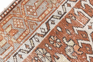 This is an antique Persian Heriz runner, a handmade rug in red and green tones, featuring a Karaja design.