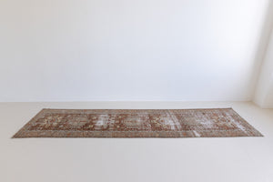 A vintage Persian Heriz runner in red and green tones — this hand-knotted antique carpet showcases a Karaja design.