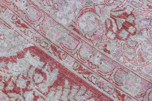 Detail of a genuine antique Persian Sarouk carpet in red and blue tones, a handmade rug with a floral medallion design.