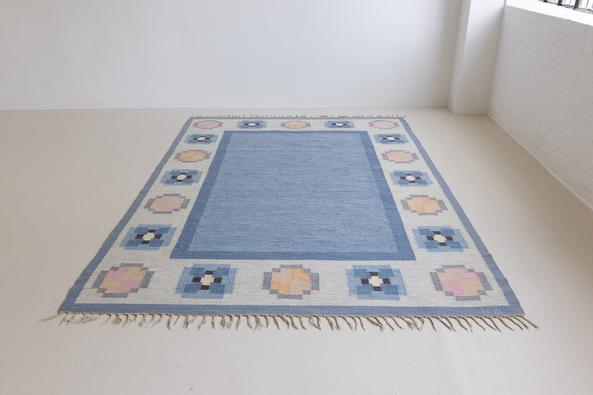 Handwoven vintage Swedish flatweave rug with a blue ground and elegant geometric border, by Gitt Grannsjo-Carlsson