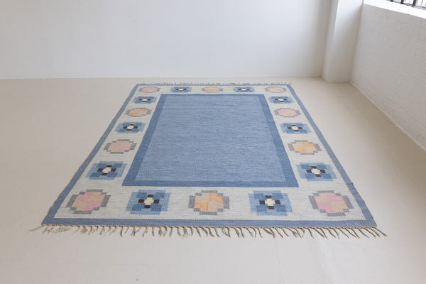 Handwoven vintage Swedish flatweave rug with a blue ground and elegant geometric border, by Gitt Grannsjo-Carlsson