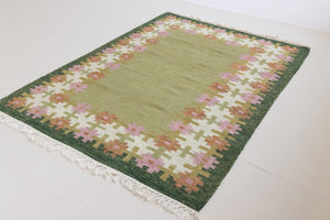 Handwoven vintage Swedish rug in green with a pretty geometric border in pink and rust