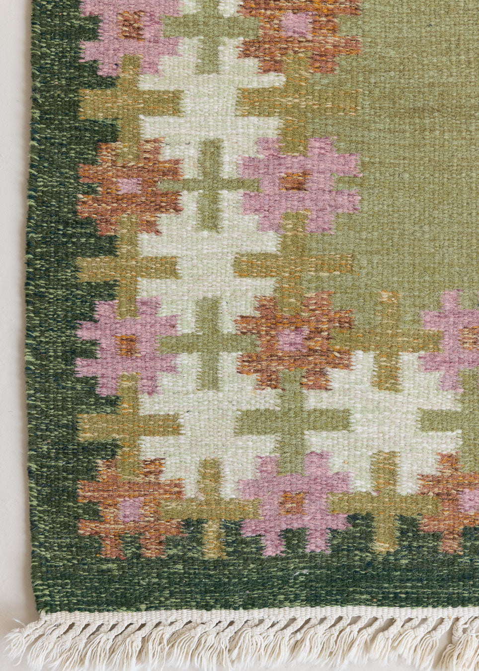 An original mid-century vintage Swedish flatweave rug in soft greens with accents of pink and rust