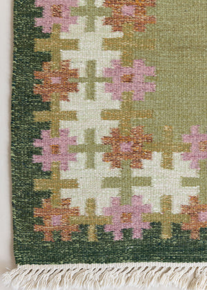 An original mid-century vintage Swedish flatweave rug in soft greens with accents of pink and rust