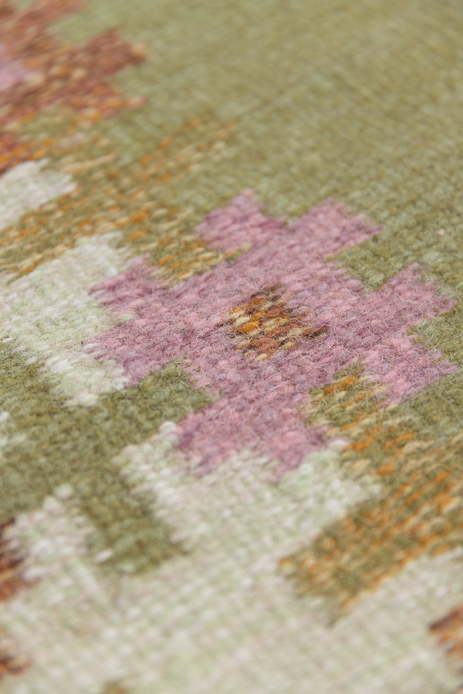 An original mid-century vintage Swedish flatweave rug in soft greens with accents of pink and rust