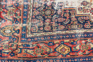 Raine is a beautiful antique Senneh rug with an intricate design. Senneh rugs are known for their fine and intricate patterns and distinctive weaving technique. Raine has a central motif surrounded by an intricate pattern and a pleasing colour palette of blue, red and taupe.