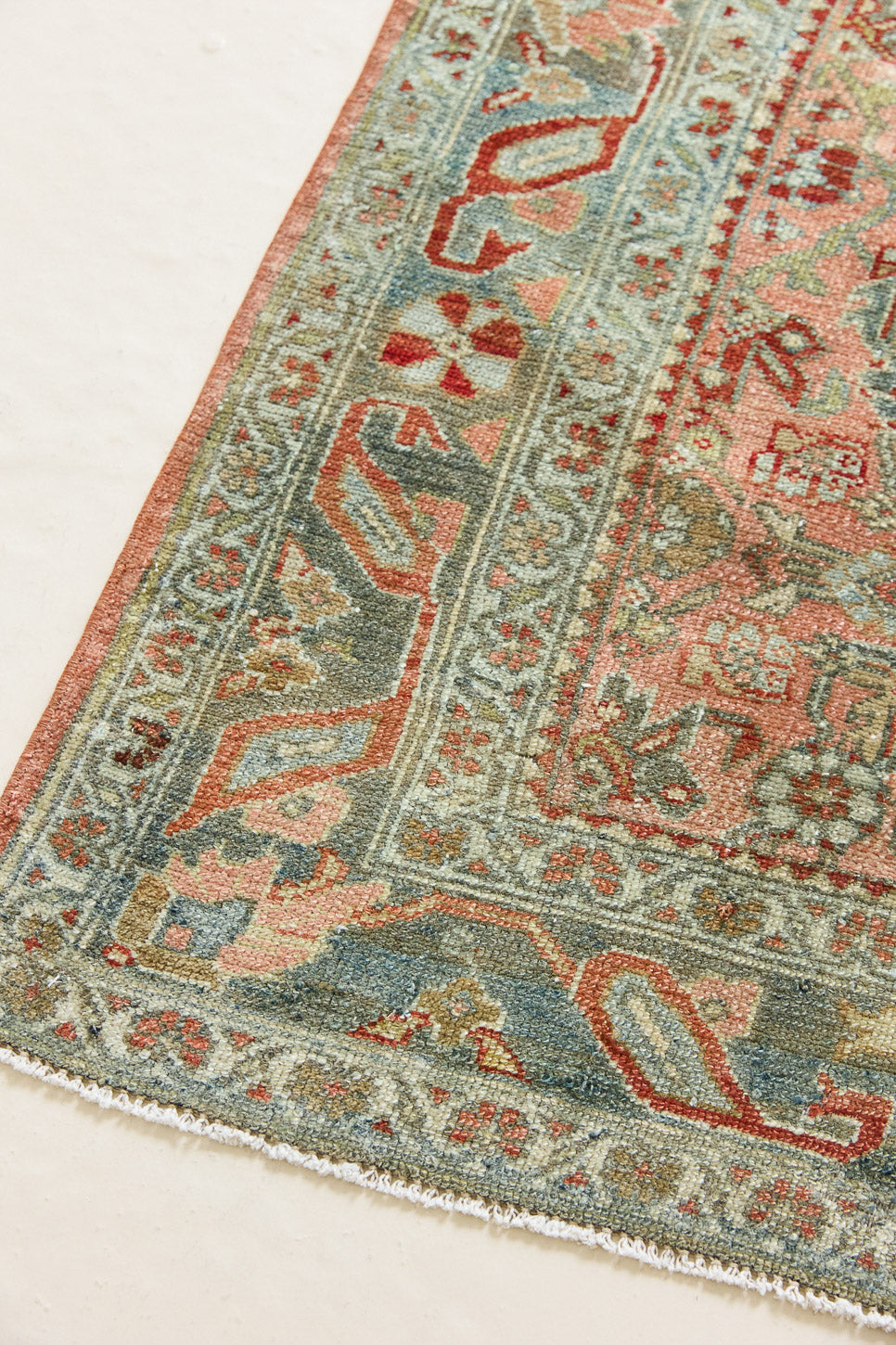 Celine is a beautiful Hamedan rug featuring a rusty pink field, blue border and a decorative all over floral design