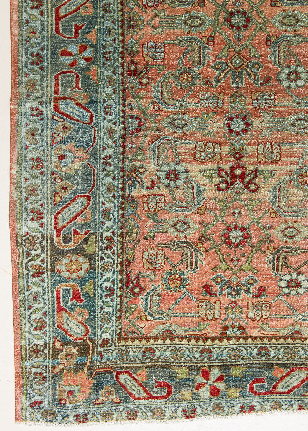 Celine is a beautiful Hamedan rug featuring a rusty pink field, blue border and a decorative all over floral design