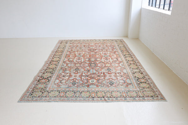 Mahals are known for decorative designs and repeating floral patterns. This antique rug features a beautiful earthy red ground complimented by a dark blue border.