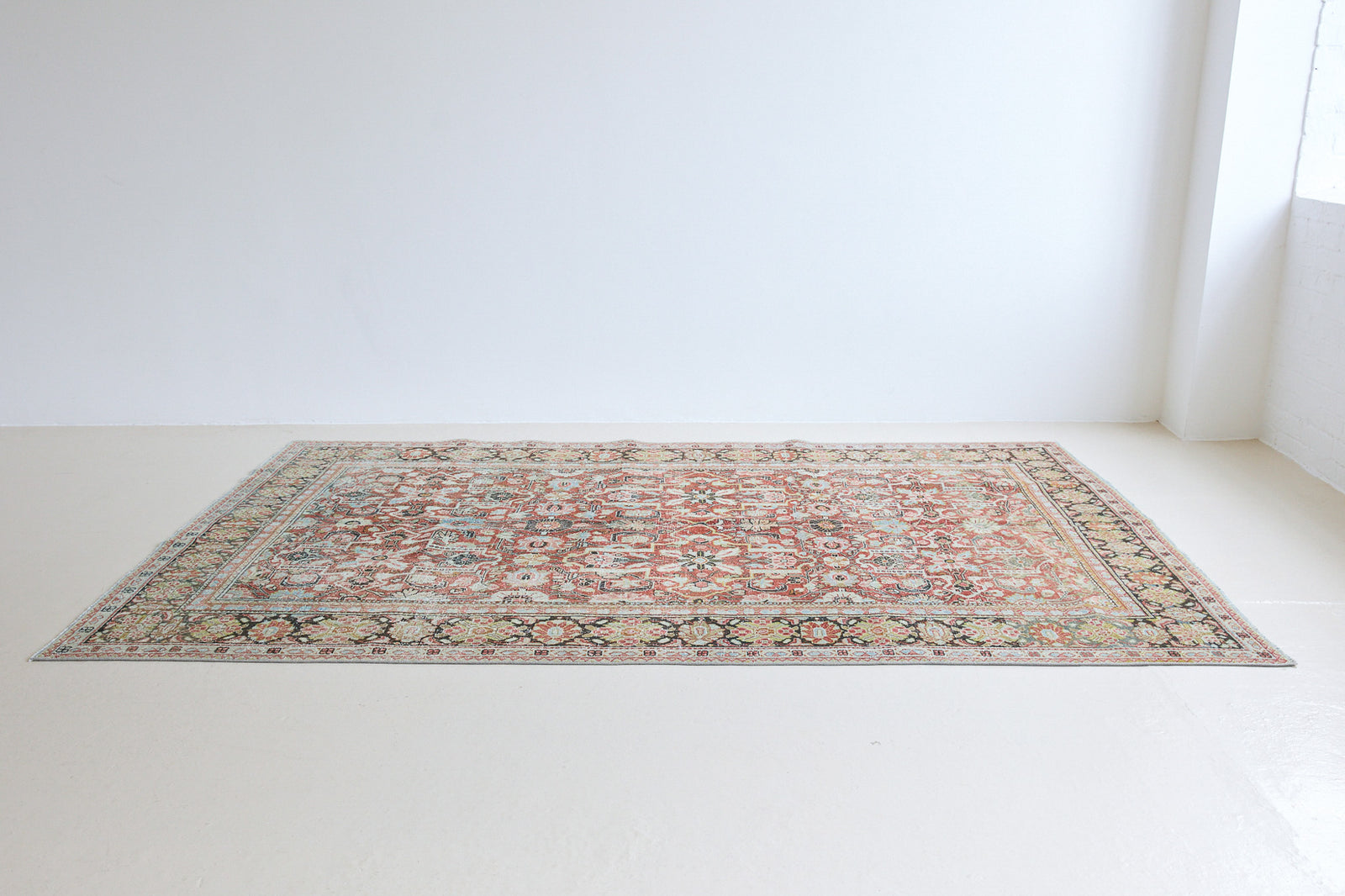Mahals are known for decorative designs and repeating floral patterns. This antique rug features a beautiful earthy red ground complimented by a dark blue border.