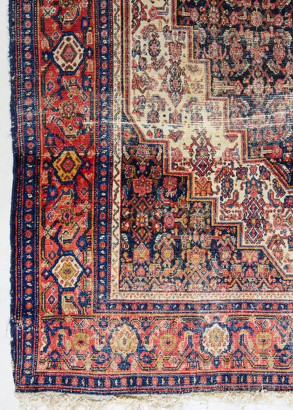 Raine is a beautiful antique Senneh rug with an intricate design. Senneh rugs are known for their fine and intricate patterns and distinctive weaving technique. Raine has a central motif surrounded by an intricate pattern and a pleasing colour palette of blue, red and taupe.