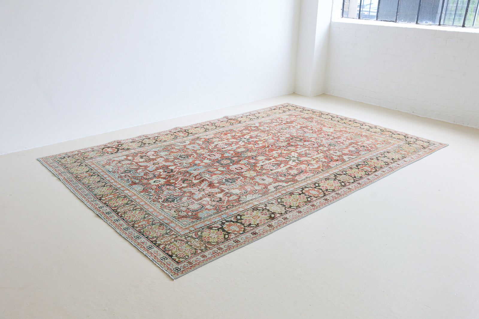 Mahals are known for decorative designs and repeating floral patterns. This antique rug features a beautiful earthy red ground complimented by a dark blue border.