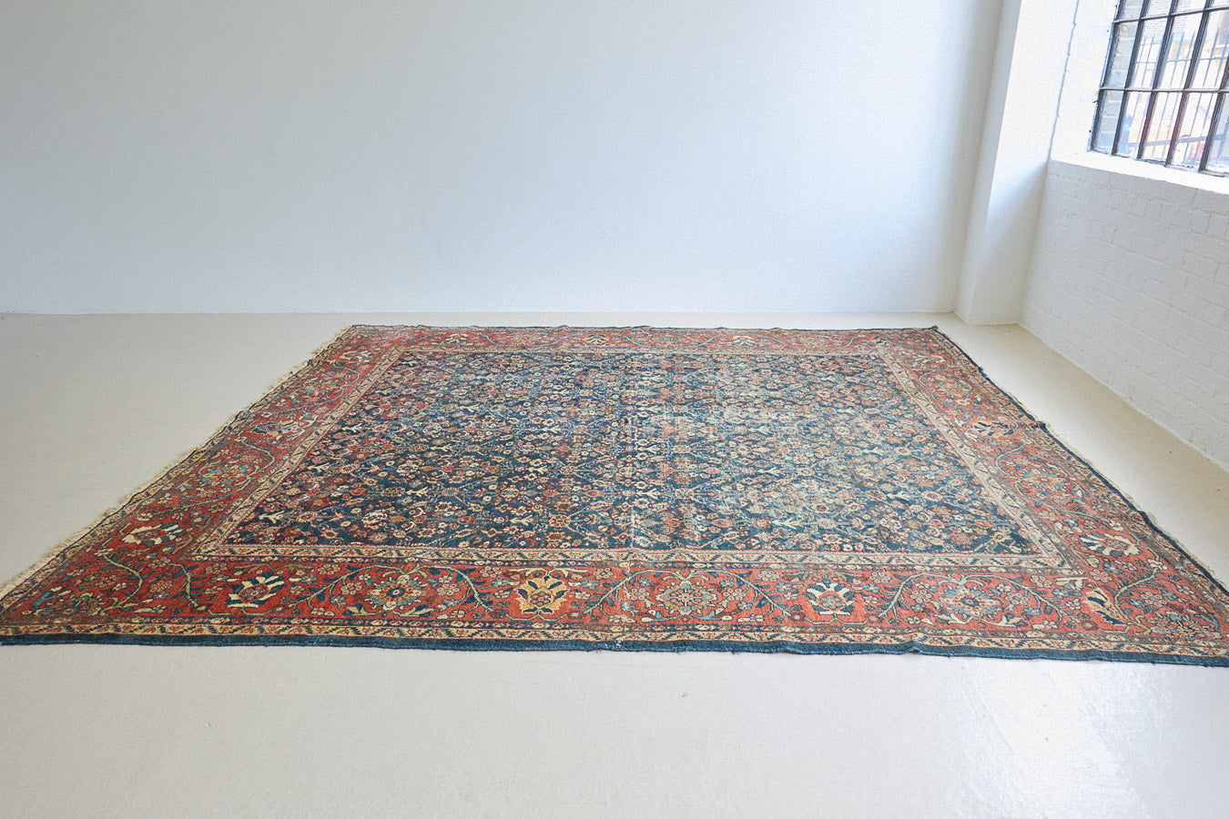 Farahan rugs are known for their high quality and are some of the most valuable Persian styles known for their repeating all over designs. Adeline is a large rug featuring a beautiful, intricate all over design on a dark blue ground with red boarder.