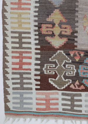 Close-up of a vintage Anatolian kilim rug with muted geometric designs on a white background