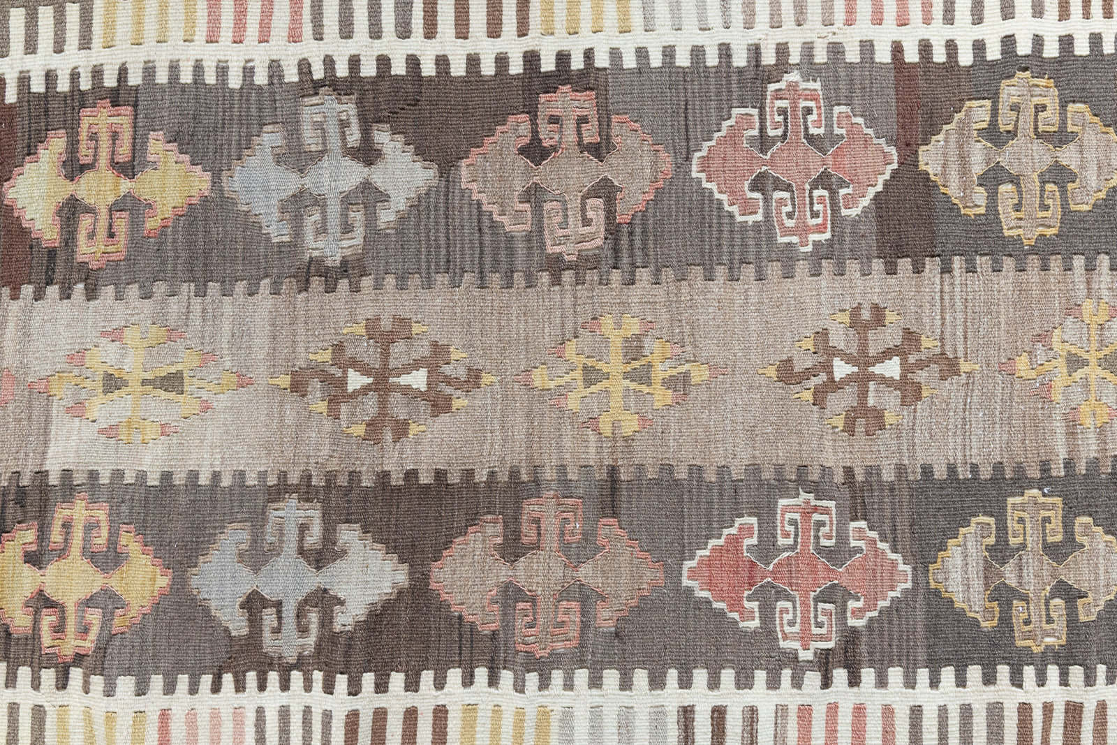 Nesa is a vintage Anatolian kilim rug with muted geometric designs on a white background
