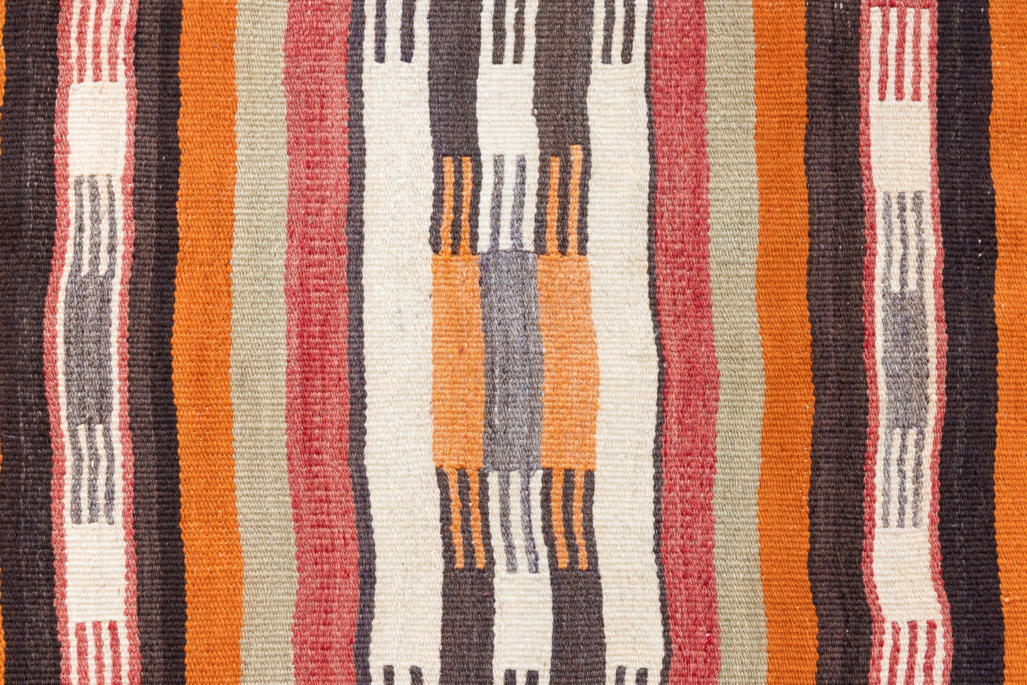 A South Anatolian nomadic kilim runner. Hand-woven on village and nomadic looms in vivid, naturally dyed colours, a tradition stretching back thousands of years. Vespa features a bold stripe pattern in earthy hues of rust, orange, taupe and black.