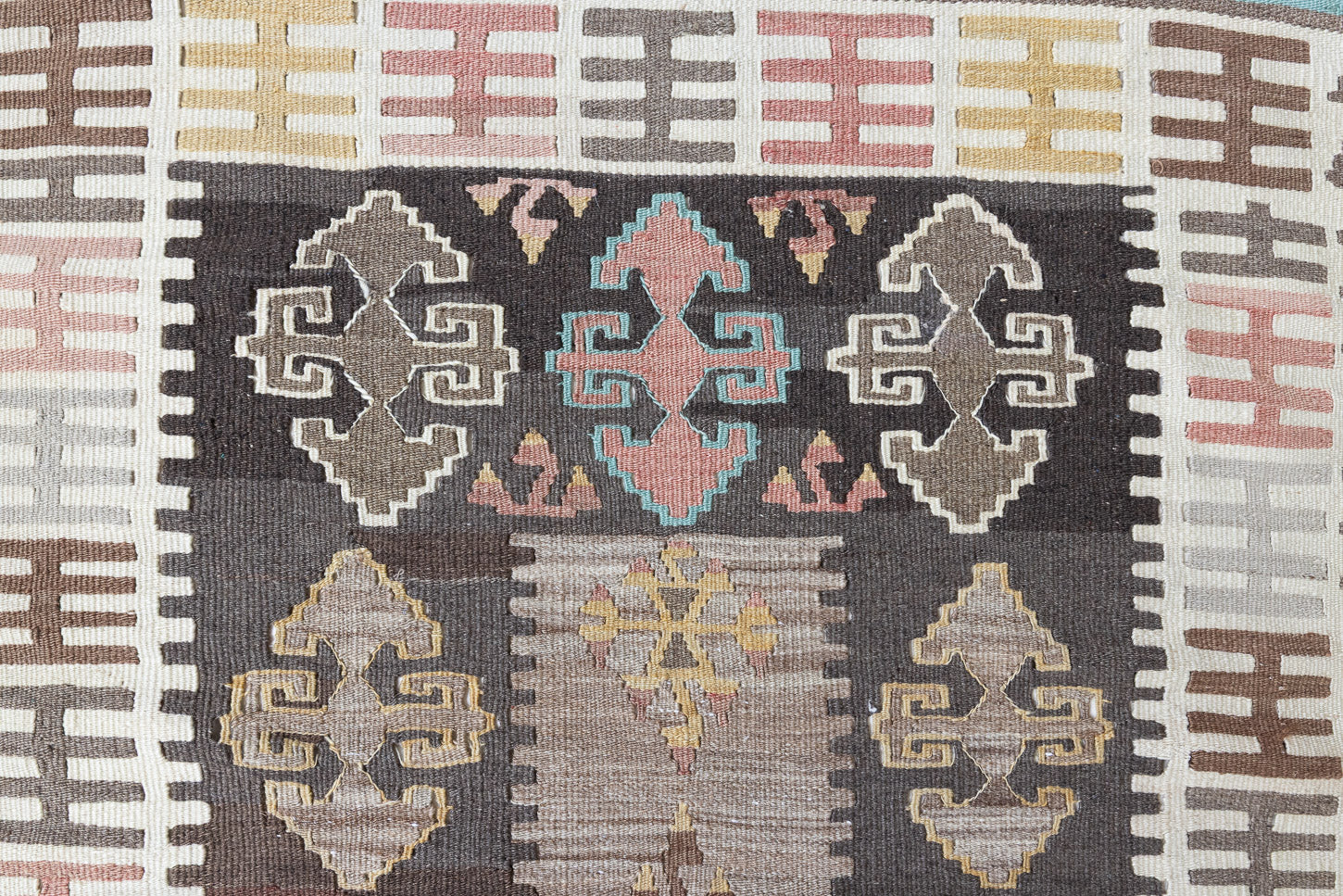 Nesa is a vintage Anatolian kilim rug with muted geometric designs on a white background