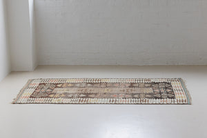 Nesa is a vintage Anatolian kilim rug with muted geometric designs on a white background