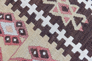Delphi is a bold, geometric Anatolian kilim. Hand-woven on village and nomadic looms in vivid, naturally dyed colours, a tradition stretching back thousands of years. Kilims were woven for the practicalities of daily life and used as floor and wall coverings, storage bags, and prayer mats. Delphi features a rosey pink field scattered with a geometric motif. A black border is decorated with the Anatolian star motif traditionally associated with happiness.