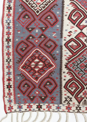 Zerrin is a bold, geometric Anatolian Hakkari kilim. Hand-woven on village and nomadic looms in vivid, naturally dyed colours, a tradition stretching back thousands of years. Kilims were woven for the practicalities of daily life and used as floor and wall coverings, storage bags, and prayer mats. Zerrin features a taupe and grey striped field scattered with the classic hand-on-hips motif, bordered by the comb motif both traditionally associated with marriage and fertility.