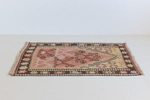 Delphi is a bold, geometric Anatolian kilim. Hand-woven on village and nomadic looms in vivid, naturally dyed colours, a tradition stretching back thousands of years. Kilims were woven for the practicalities of daily life and used as floor and wall coverings, storage bags, and prayer mats. Delphi features a rosey pink field scattered with a geometric motif. A black border is decorated with the Anatolian star motif traditionally associated with happiness.