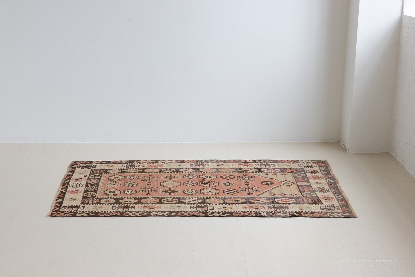 Solenne is a Central Anatolian Gömürgen Kilim rug. These kilims are hand-woven from locally sourced naturally dyed wool, a tradition stretching back thousands of years. Gömürgen kilims are known for their distinctive coal-black tones. Solenne features the classic star, eye, and comb motifs - long believed to bring happiness, ward off harm, and symbolise marriage and fertility.