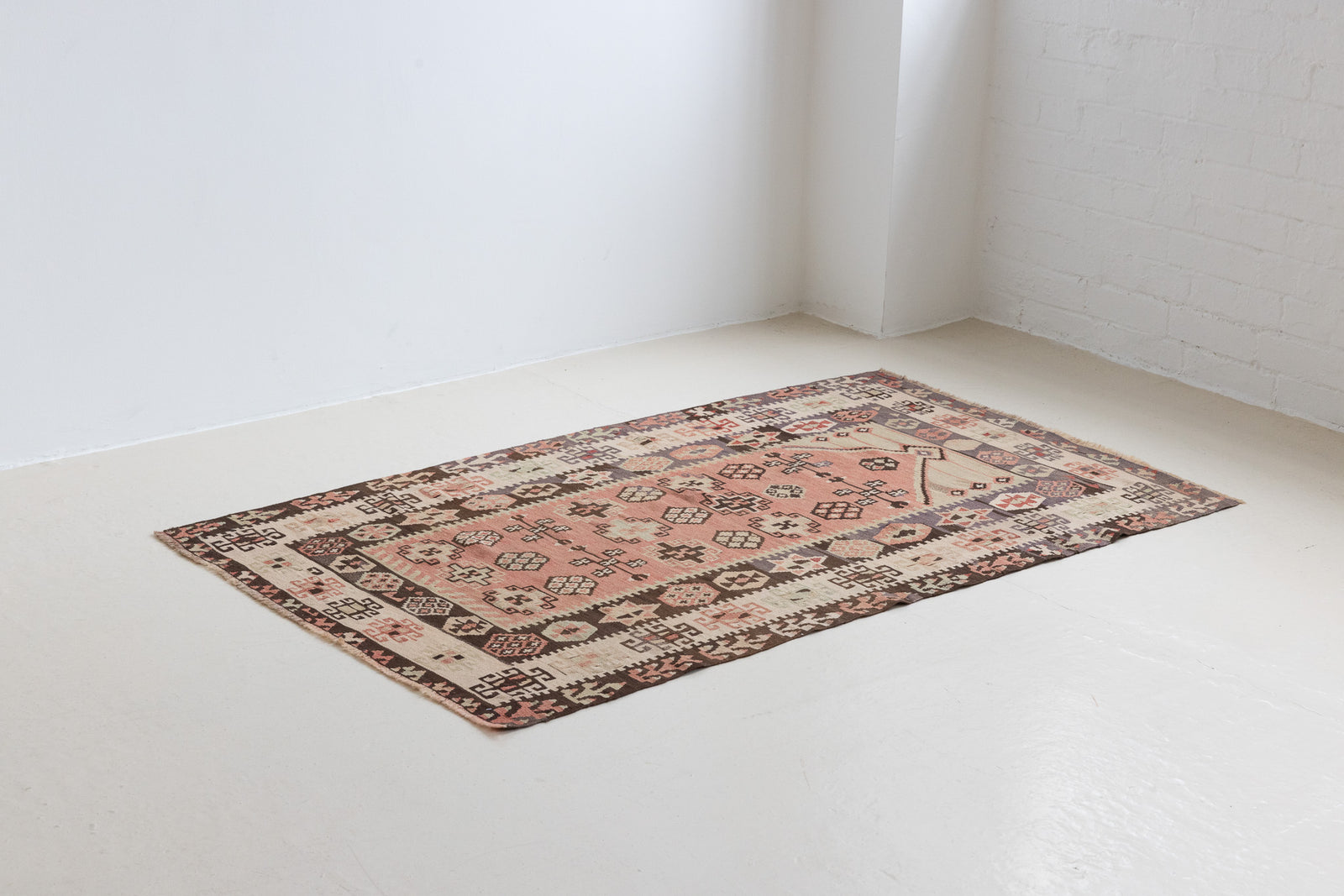 Solenne is a Central Anatolian Gömürgen Kilim rug. These kilims are hand-woven from locally sourced naturally dyed wool, a tradition stretching back thousands of years. Gömürgen kilims are known for their distinctive coal-black tones. Solenne features the classic star, eye, and comb motifs - long believed to bring happiness, ward off harm, and symbolise marriage and fertility.