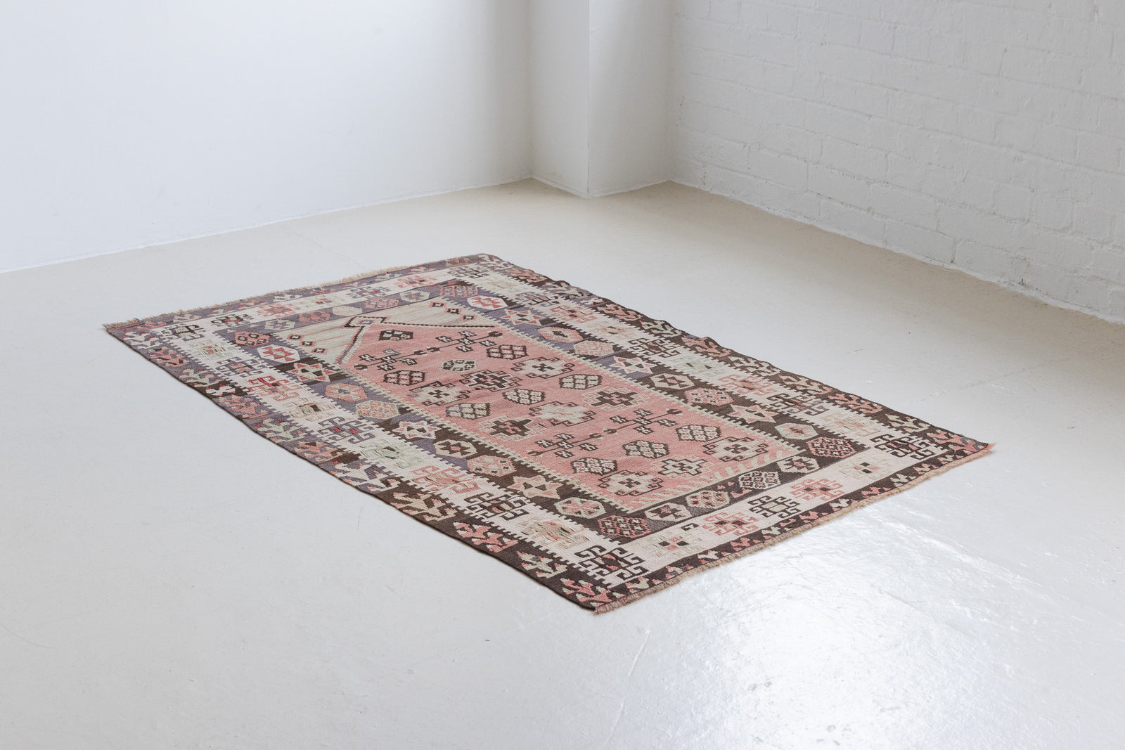 Solenne is a Central Anatolian Gömürgen Kilim rug. These kilims are hand-woven from locally sourced naturally dyed wool, a tradition stretching back thousands of years. Gömürgen kilims are known for their distinctive coal-black tones. Solenne features the classic star, eye, and comb motifs - long believed to bring happiness, ward off harm, and symbolise marriage and fertility.