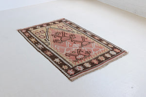 Delphi is a bold, geometric Anatolian kilim. Hand-woven on village and nomadic looms in vivid, naturally dyed colours, a tradition stretching back thousands of years. Kilims were woven for the practicalities of daily life and used as floor and wall coverings, storage bags, and prayer mats. Delphi features a rosey pink field scattered with a geometric motif. A black border is decorated with the Anatolian star motif traditionally associated with happiness.