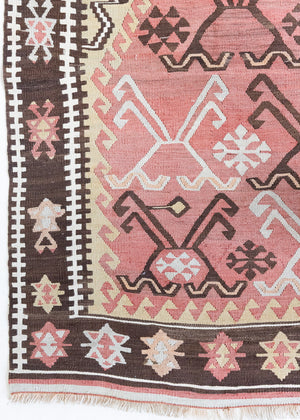 Delphi is a bold, geometric Anatolian kilim. Hand-woven on village and nomadic looms in vivid, naturally dyed colours, a tradition stretching back thousands of years. Kilims were woven for the practicalities of daily life and used as floor and wall coverings, storage bags, and prayer mats. Delphi features a rosey pink field scattered with a geometric motif. A black border is decorated with the Anatolian star motif traditionally associated with happiness.