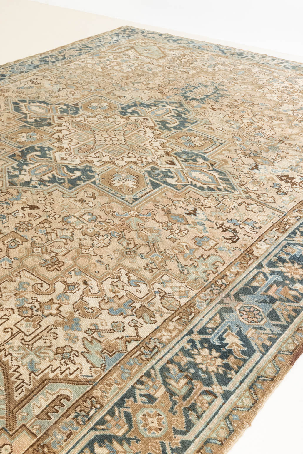 This is a vintage Persian Heriz rug that has been over-dyed to gently fade its original colours, giving a more neutral palette. Persia has the most desirable rugs and carpets with stunning designs such as this carpet. Now available at Ourika London.
