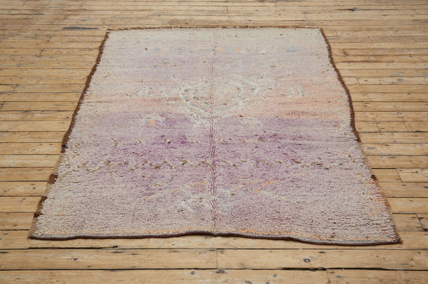 A vintage Boujad rug with a floral and geometric pattern, primarily in shades of pink and orange, showcasing natural dyes.