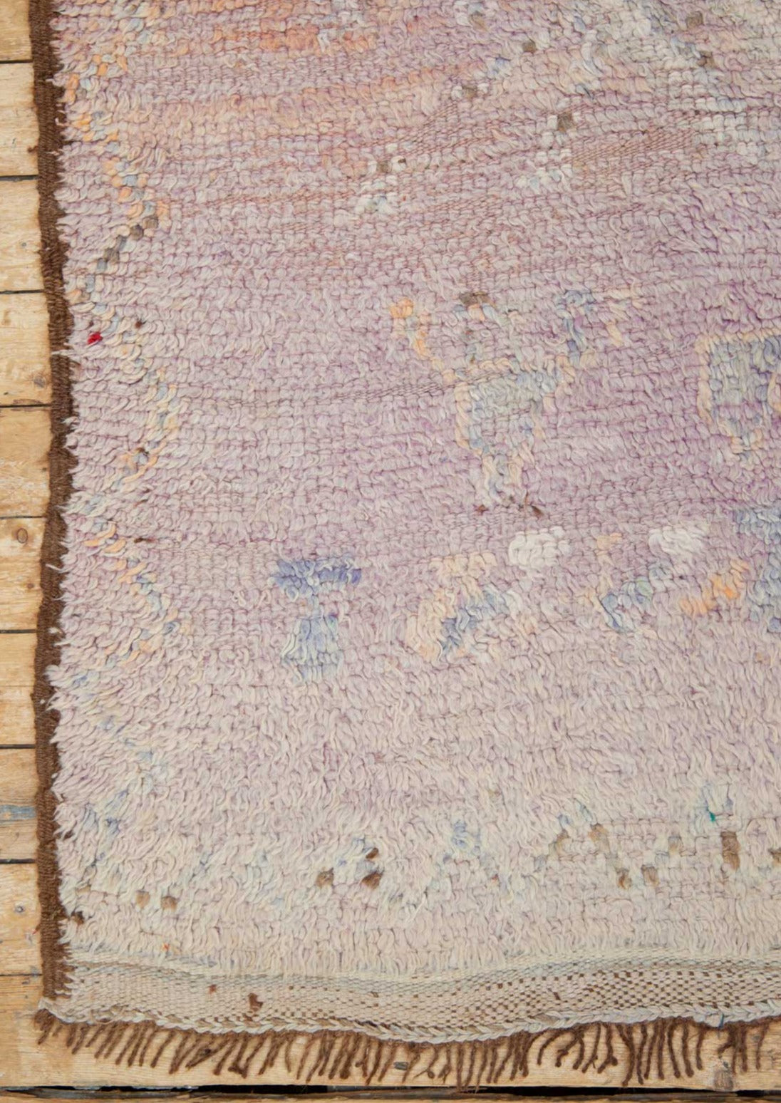 A vintage Boujad rug with a floral and geometric pattern, primarily in shades of pink and orange, showcasing natural dyes.