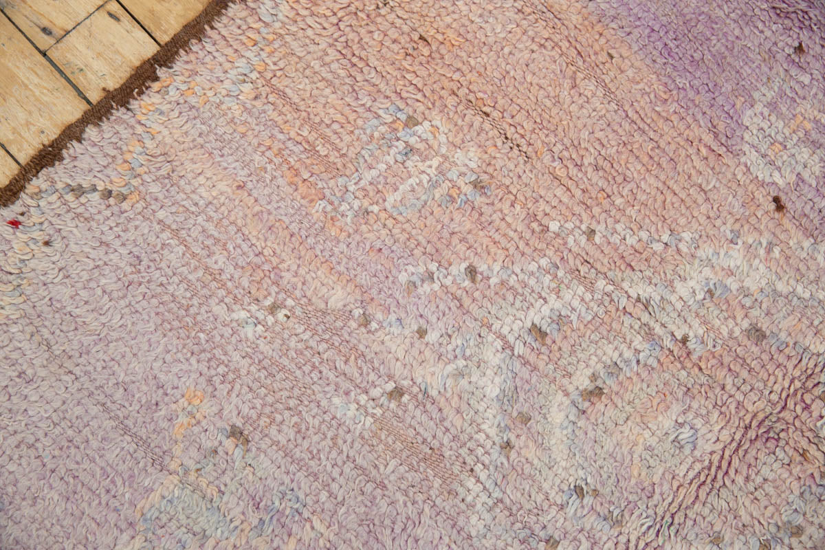 A vintage Boujad rug with a floral and geometric pattern, primarily in shades of pink and orange, showcasing natural dyes.