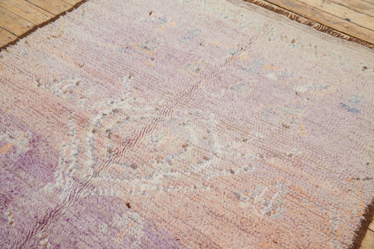 A vintage Boujad rug with a floral and geometric pattern, primarily in shades of pink and orange, showcasing natural dyes.