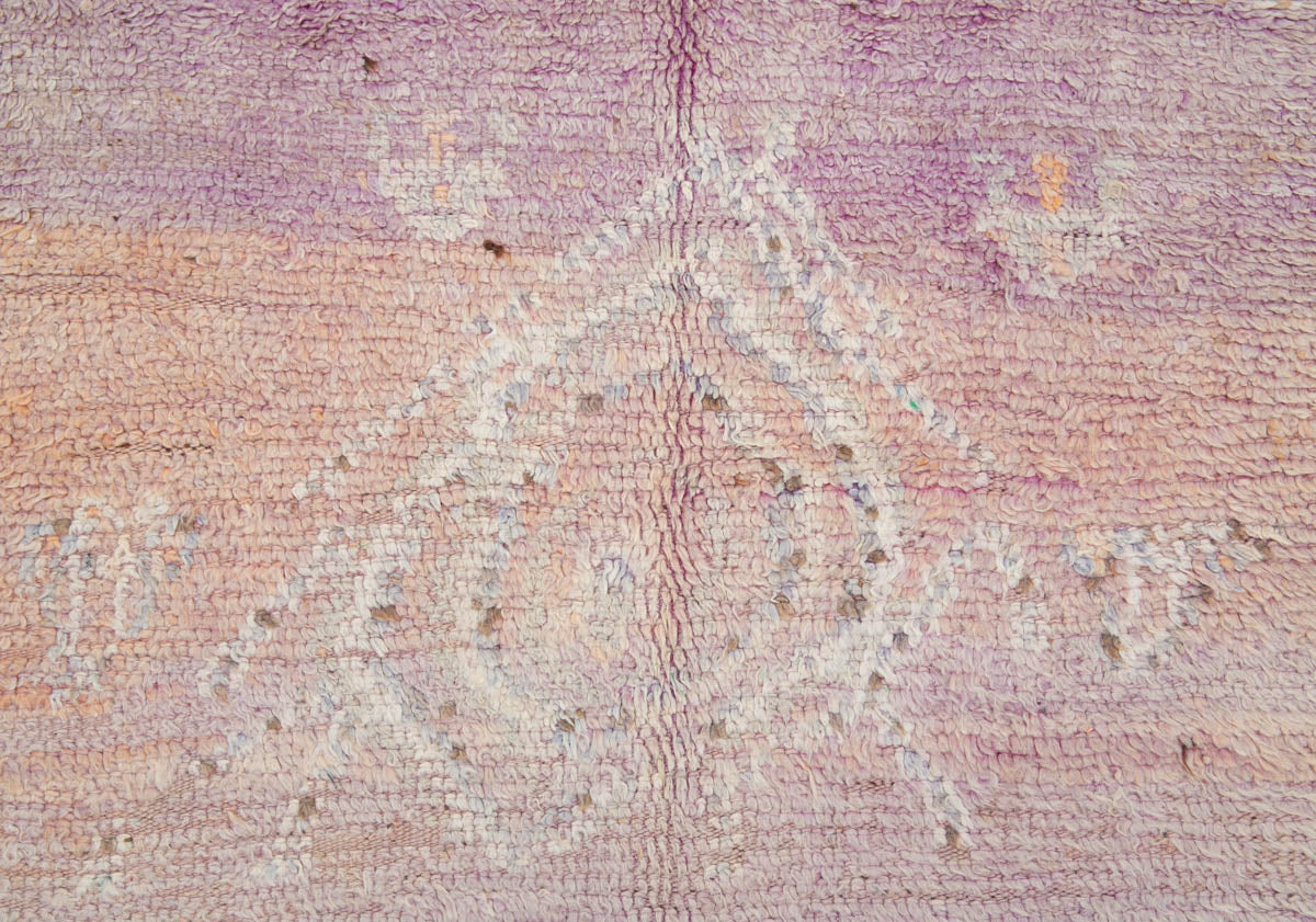 A vintage Boujad rug with a floral and geometric pattern, primarily in shades of pink and orange, showcasing natural dyes.