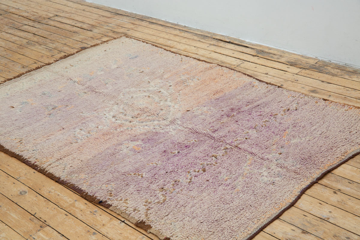 A vintage Boujad rug with a floral and geometric pattern, primarily in shades of pink and orange, showcasing natural dyes.