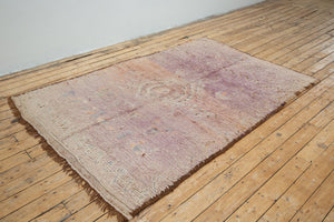 A vintage Boujad rug with a floral and geometric pattern, primarily in shades of pink and orange, showcasing natural dyes.