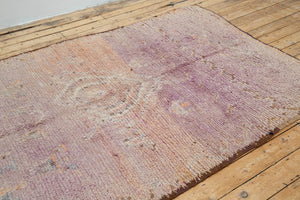 A vintage Boujad rug with a floral and geometric pattern, primarily in shades of pink and orange, showcasing natural dyes.