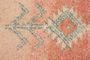 A vintage Boujad rug with a peach and sage green color palette, featuring geometric patterns and berber symbology, approximately 40 years old