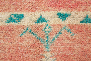A vintage Boujad rug with a peach and sage green color palette, featuring geometric patterns and berber symbology, approximately 40 years old