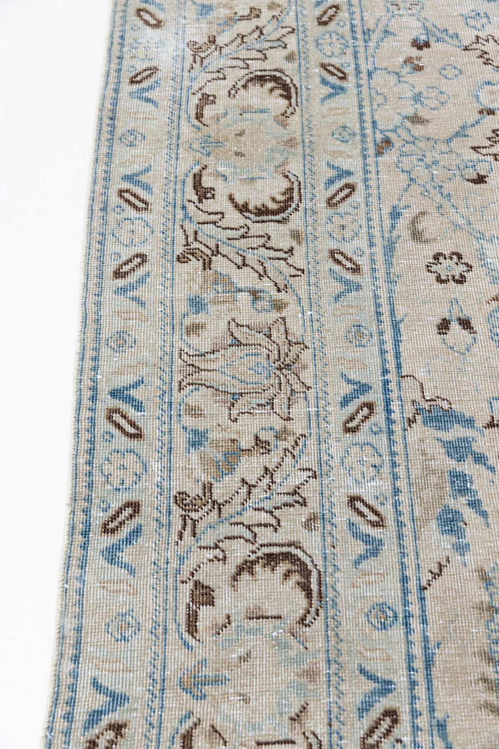 This pair of vintage handknotted Persian rugs are from the Tabriz region. Perisa is one of the oldest rug weaving centres in the world featuring floral patterns and muted colours as seen on these carpets.
