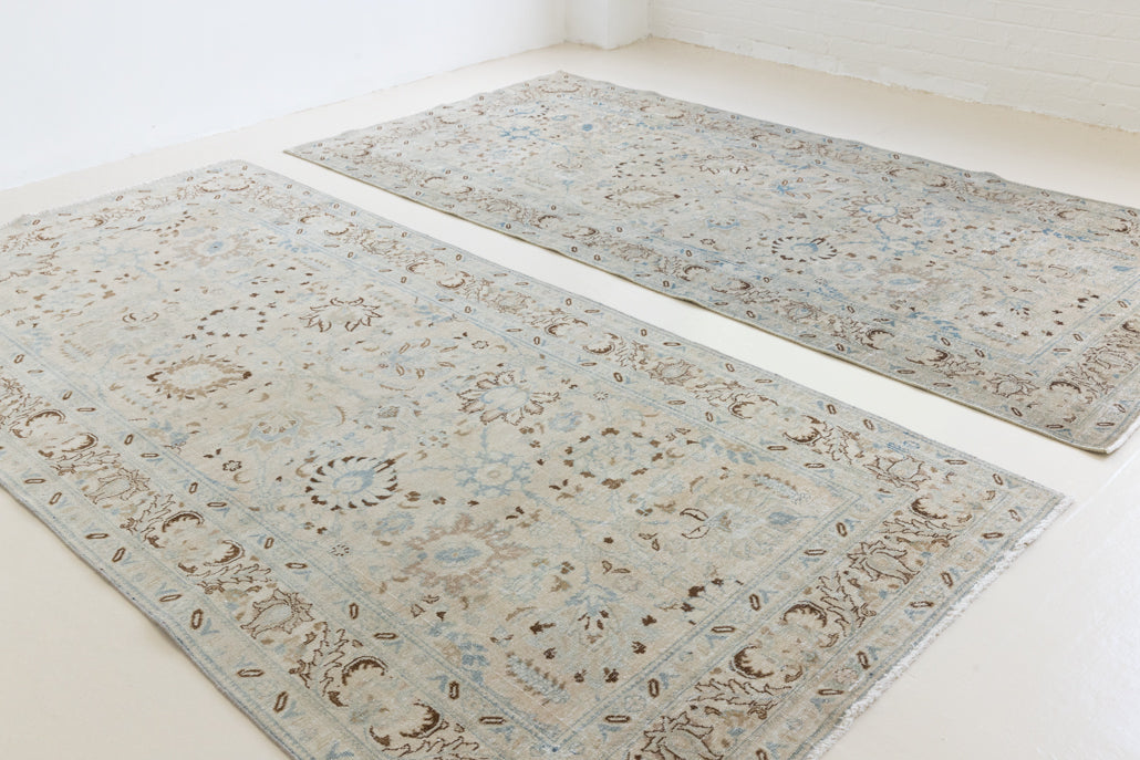 This pair of vintage handknotted Persian rugs are from the Tabriz region. Perisa is one of the oldest rug weaving centres in the world featuring floral patterns and muted colours as seen on these carpets.