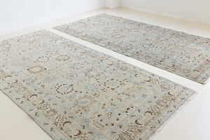 This pair of vintage handknotted Persian rugs are from the Tabriz region. Perisa is one of the oldest rug weaving centres in the world featuring floral patterns and muted colours as seen on these carpets.